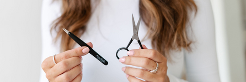 girl holding tweezers and scissors