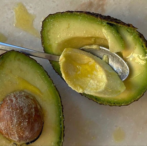 avocado being cut with spoon