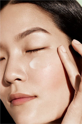 woman with skincare product on face