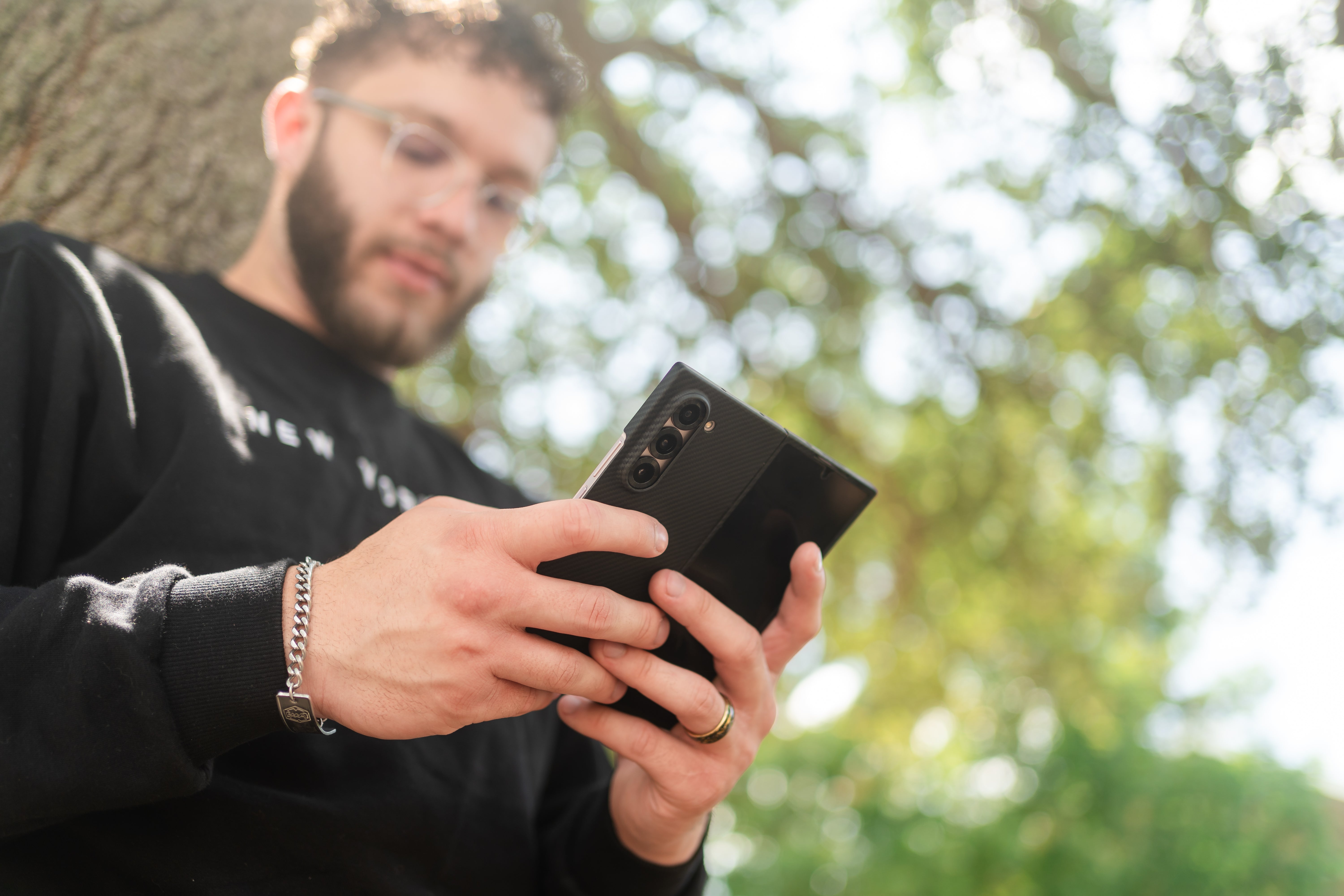 a young man holding the phone in galaxy z fold 6 aramid fiber case