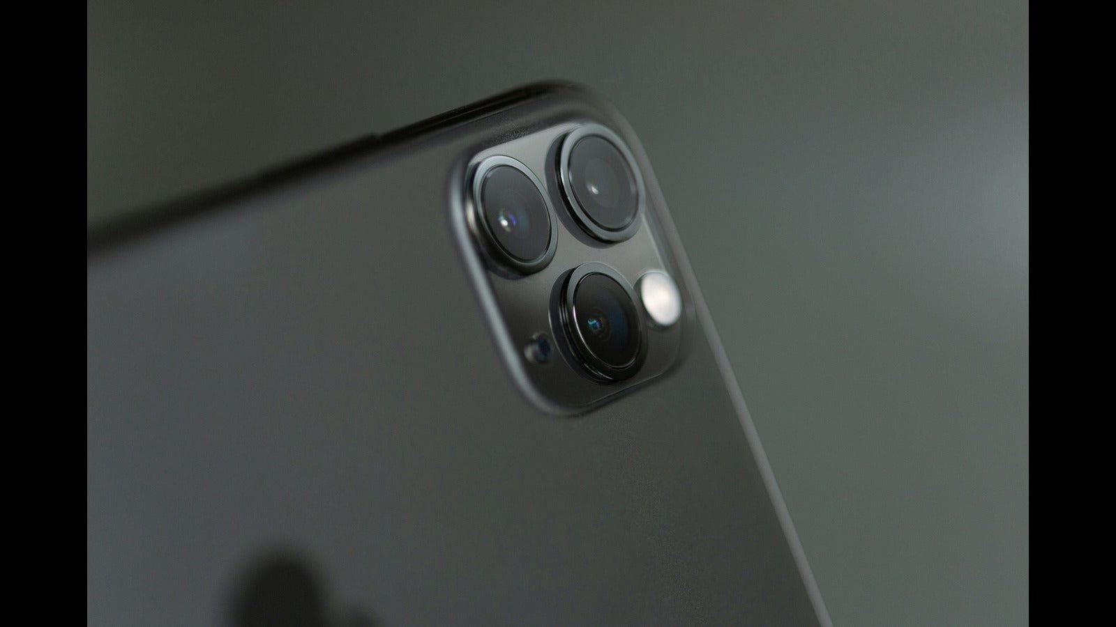 Close-up of the triple-camera system of an iPhone 15 Pro Max, showcasing the sleek design and lenses.
