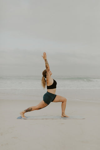 Lady in yoga pose on a beach