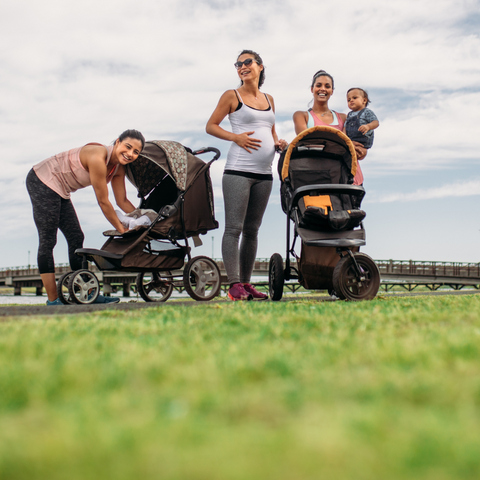 Mothers in park with buggies and children exercising