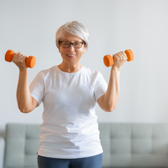 Older lady working out at home with fitness weights menopause fitness