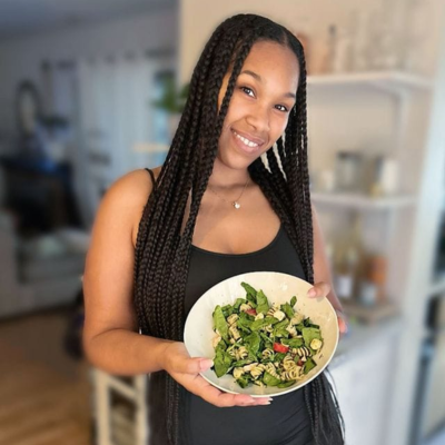 Woman smiling and holding a bowl of salad.