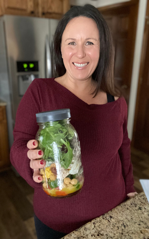 a picture of tammy overhoff holding a mason jar salad.