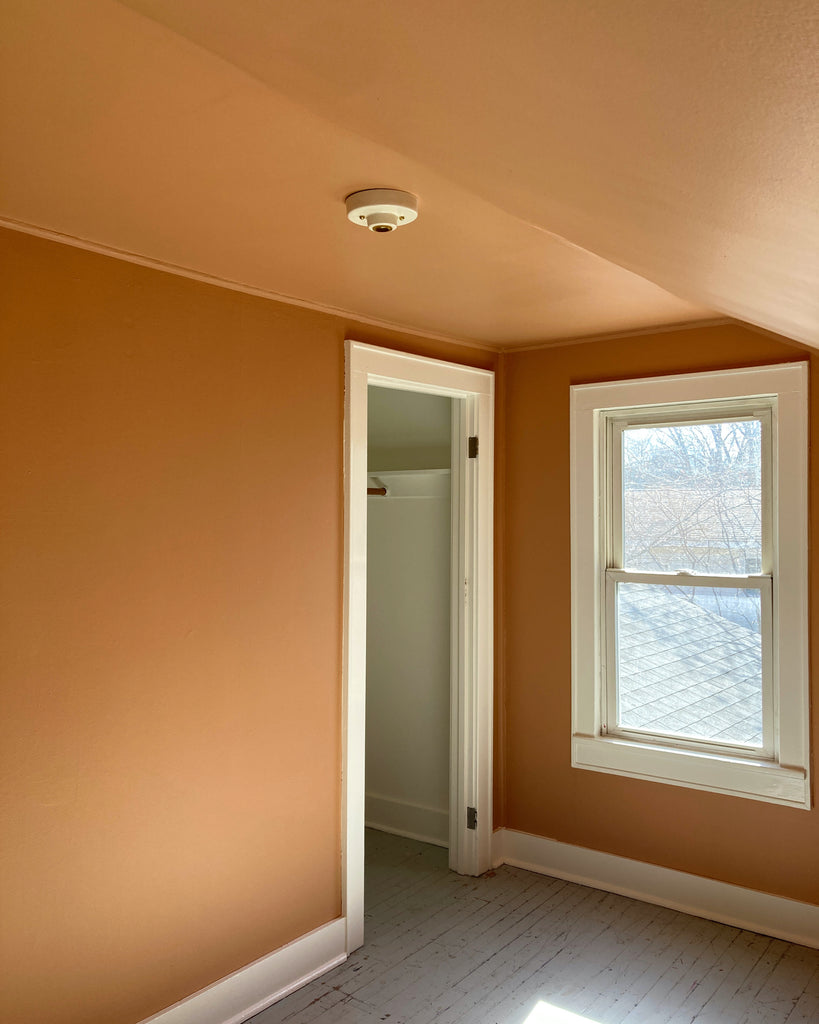 Hallie light by Quittner in buttermilk or white with brass details in guest room with terra cotta orange walls and white trim, midcentury design, old house design, vintage style