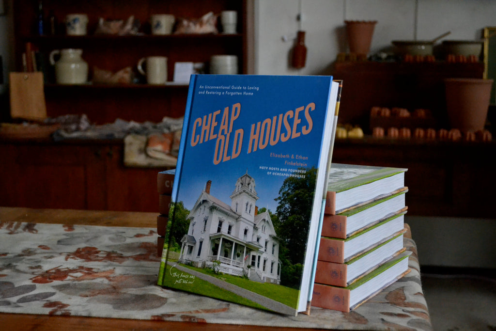 the Cheap Old Houses book on leaned up against a stack of copies on the book signing table