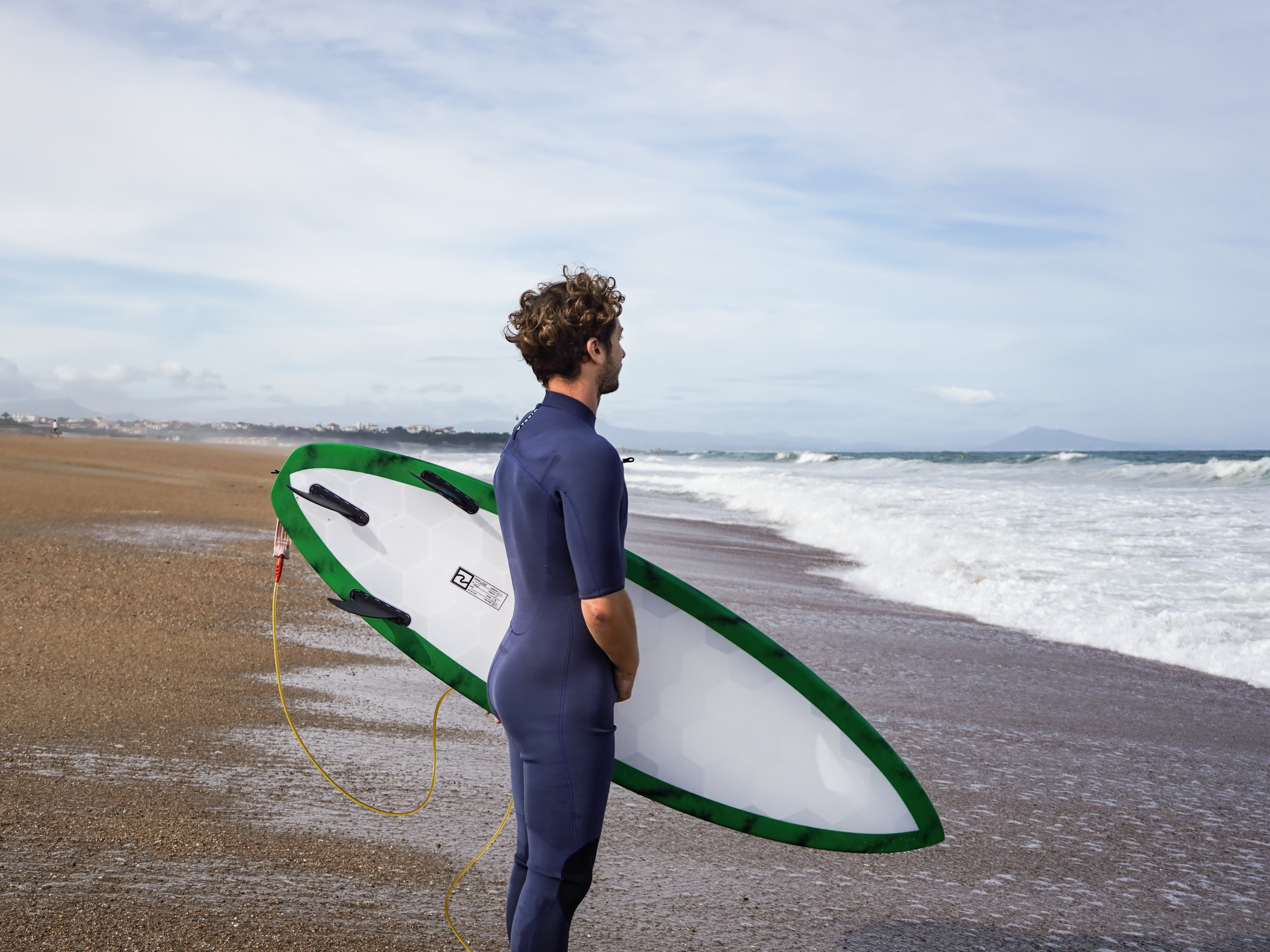 Surfista esperando en la playa con una tabla de surf Wyve