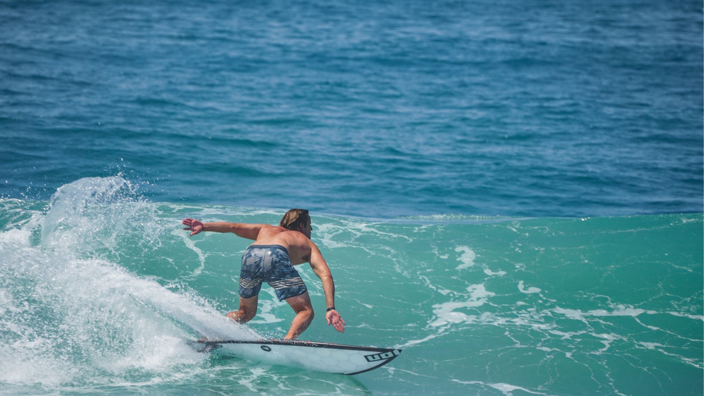 A surfer effortlessly carving a turn on a wave, demonstrating the maneuverability of a properly sized surfboard.
