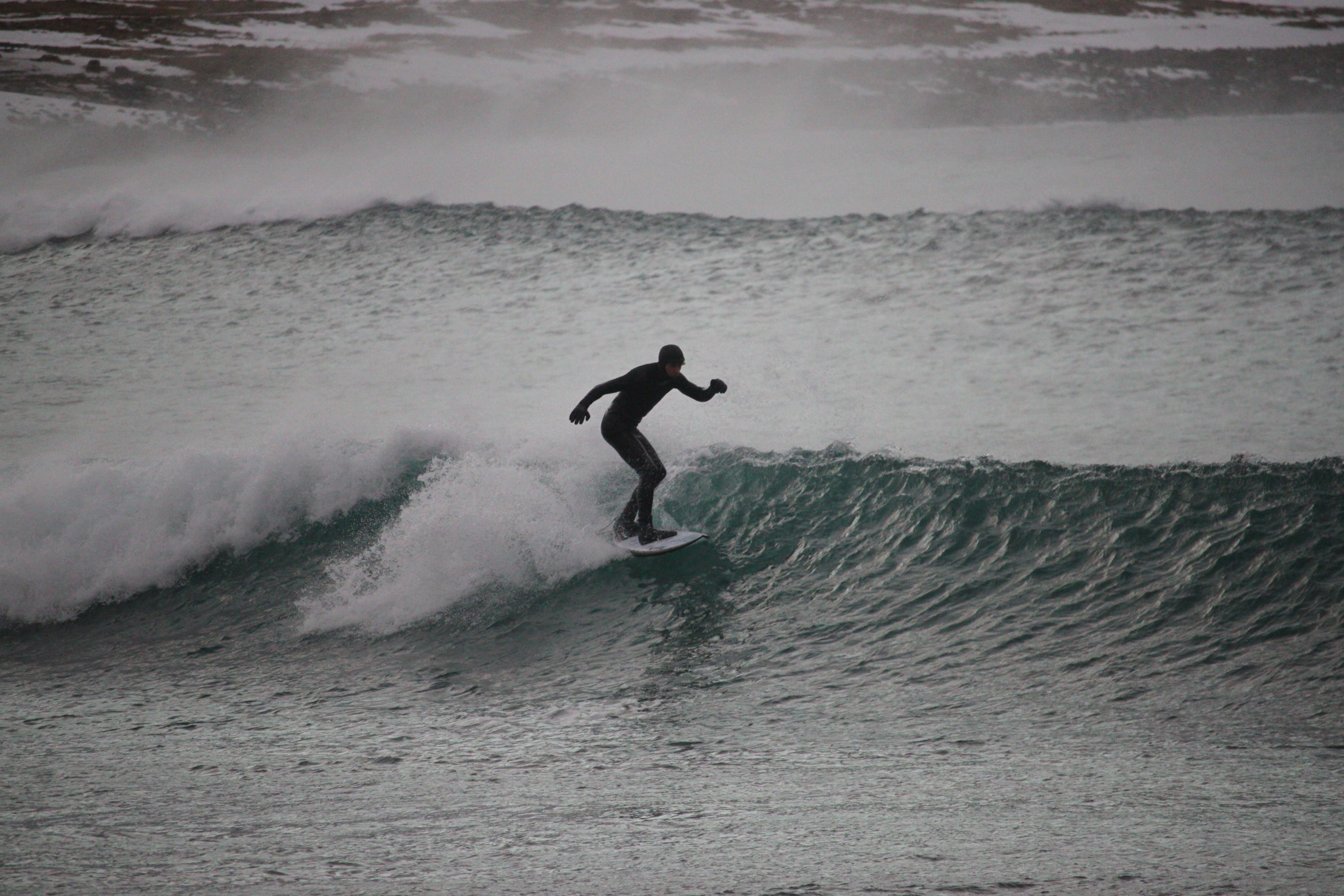 Surfer in a wave in winter using a versatille surfboard