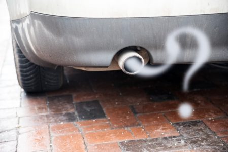 Car exhaust emitting pollution in the shape of a question mark