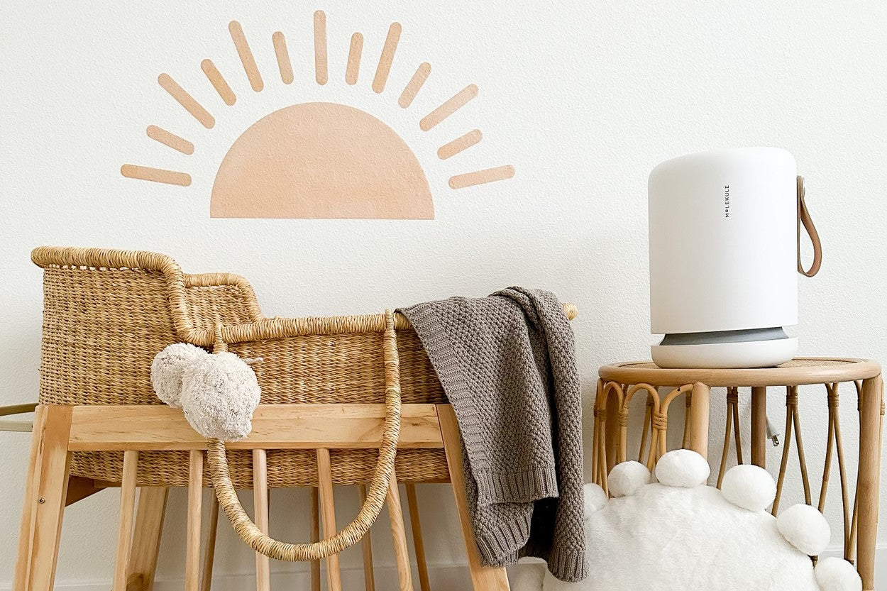 Molekule Air Mini+ air purifier next to baby crib in nursery