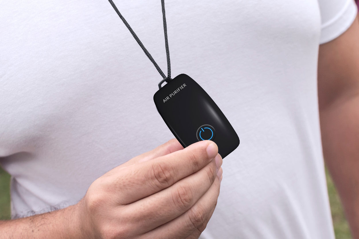 A generic tiny air purifier on a man's necklace