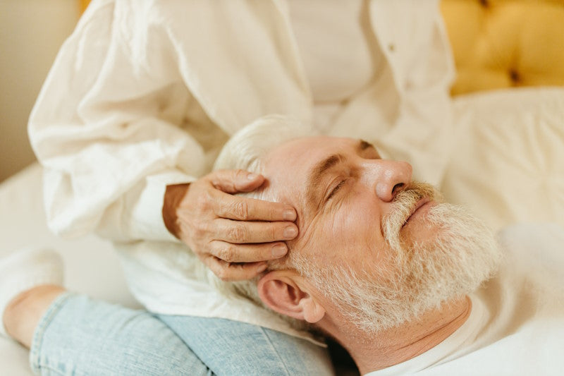 An older man getting a head massage