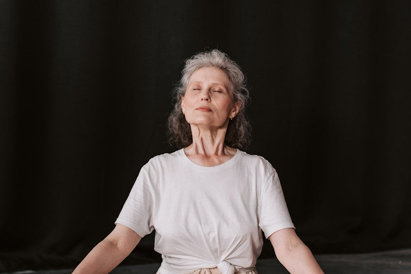 Older woman sitting on the floor meditating