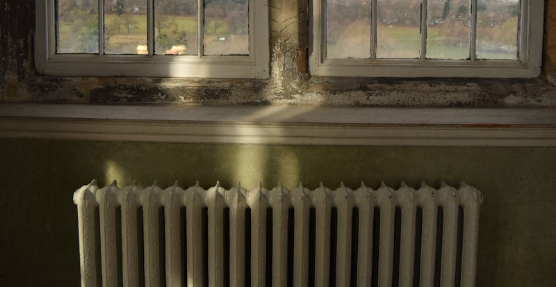 An old radiator beneath a window
