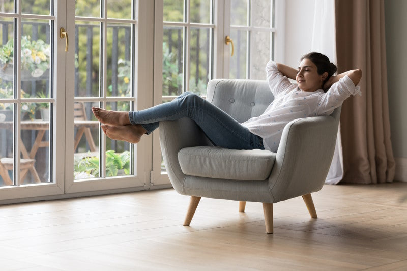 Woman relaxing in an armchair in living room