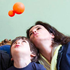 Licia Negri con il figlio e il simbolo del logo mhug, due sfere arancioni di dimensioni diverse vicine
