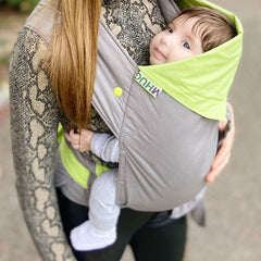 Photo of a baby smiling while being carried correctly in Mahug's Mei Tai Limelight Baby Carrier