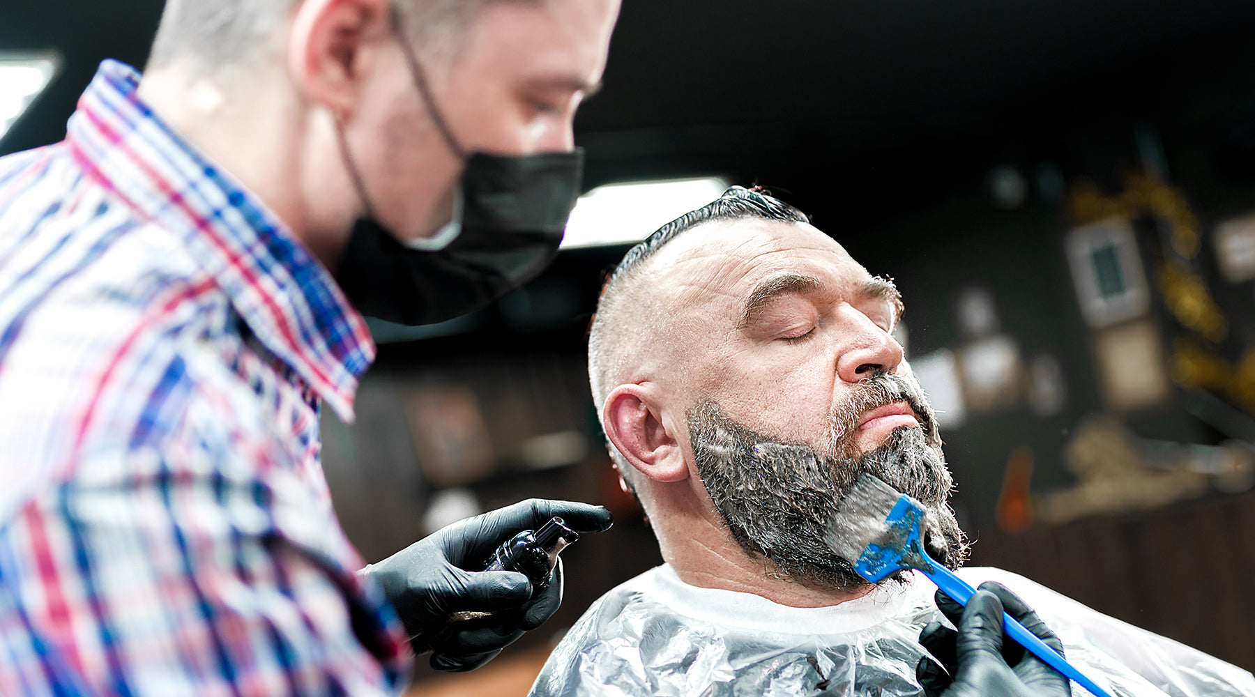 a man who is getting his beard dyed at the barbers