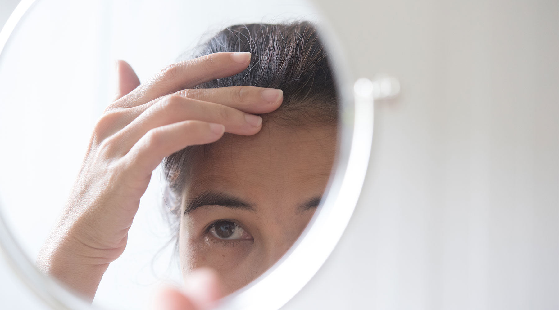 a woman considering hair conditioner for sensitive skin and scalp