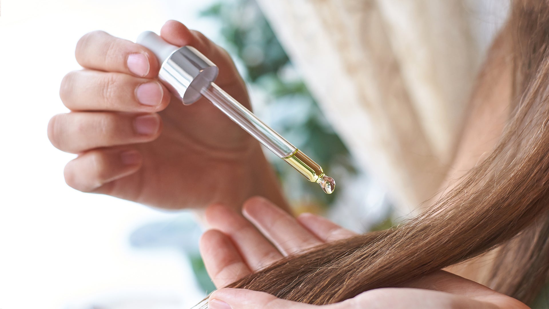 a woman using a treatment serum to get rid of greasy hair