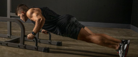 Man using Dip Station to perform Pushups