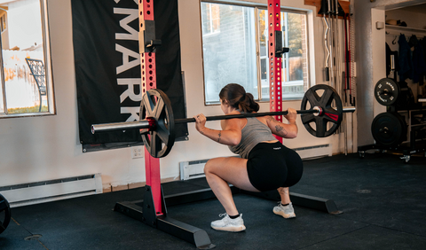 Woman squatting in squat rack