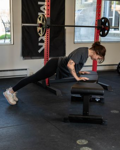 Woman doing push ups on a weight bench