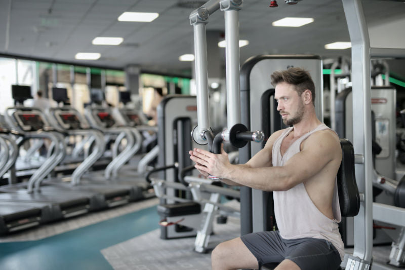 man training on exercise machine in gym