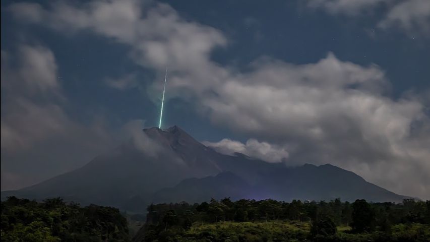 A beam of light that appears to be emitted from a volcano