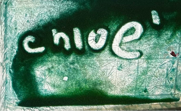 The name Chloe written in green sand atop a light table