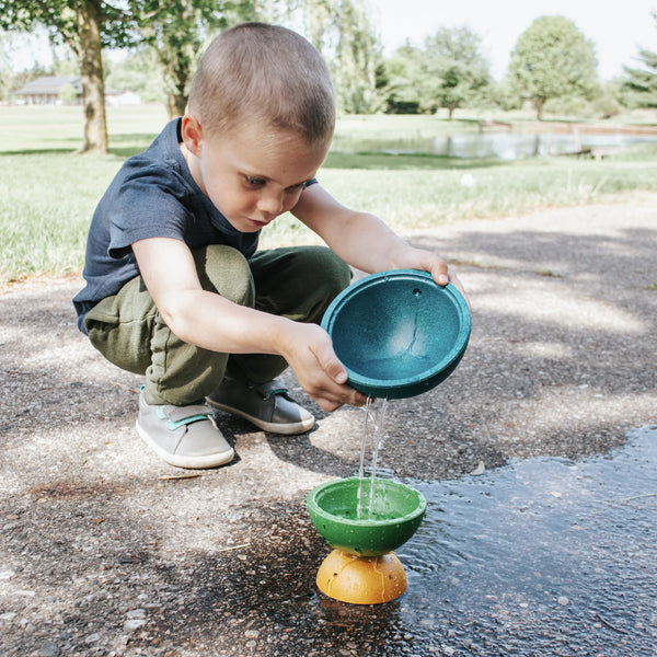 child experimenting with the flow of water in the fountain bowl set