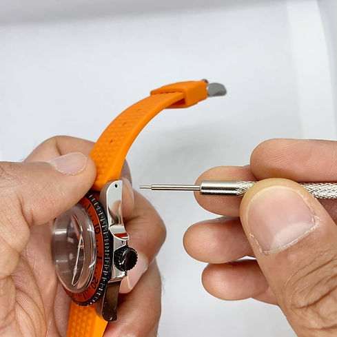 Spring bar tool about to enter outside of watch case with drilled lugs to remove watch strap