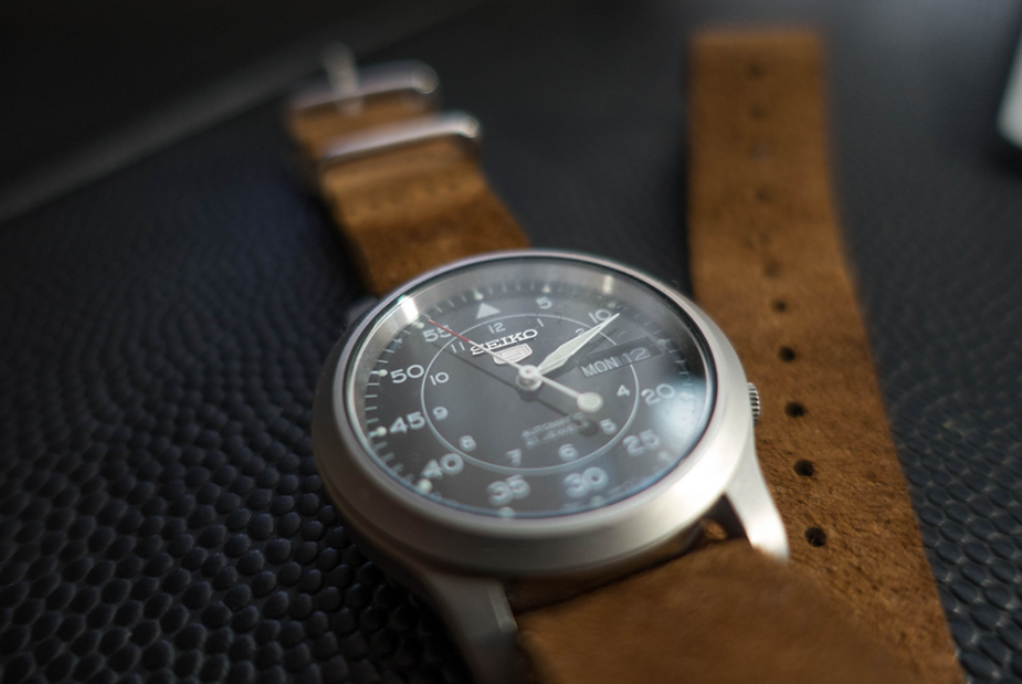 Seiko 5 watch with brown leather watch strap on soft surface table