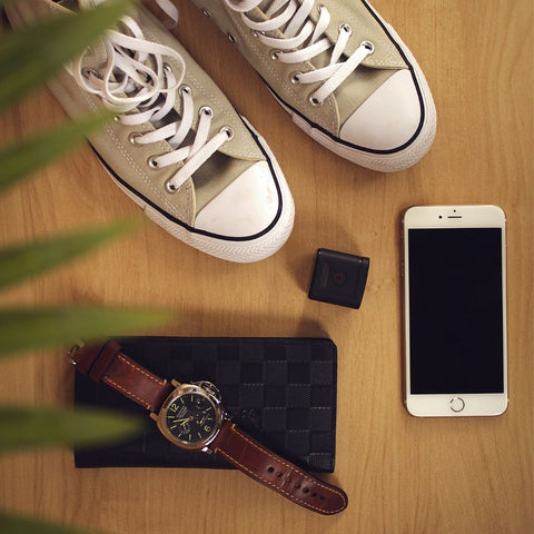 trainers with watch and brown leather watch strap and iphone