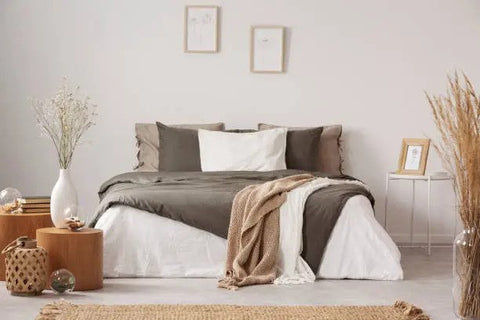 a bed with brown blanket and white pillows