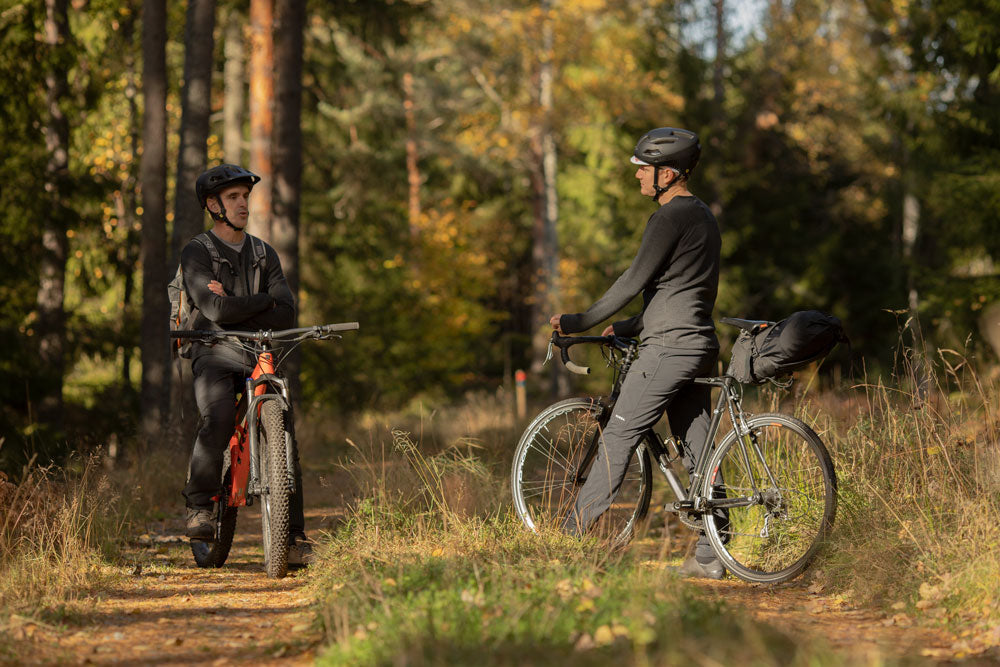 Standing with bikes in forest.