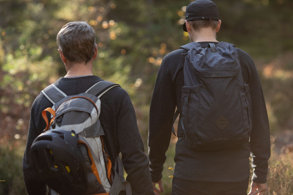 Walking with backpacks in forest.