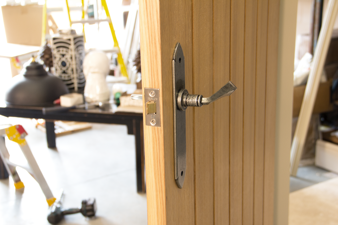 Pewter door handle and mortice latch on the edge of a wooden door