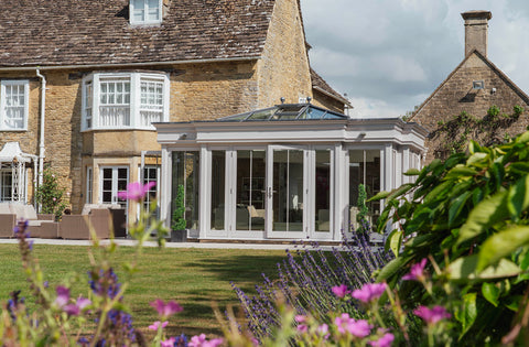 Modern orangery attatched to a cotswold stone house with From The Anvil Stainless Steel door handles and hardware.