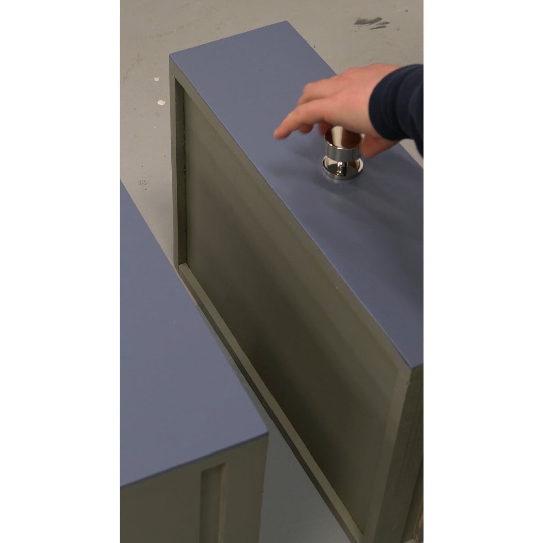 Person fitting a Polished Nickel cabinet knob to a chest of painted drawers.