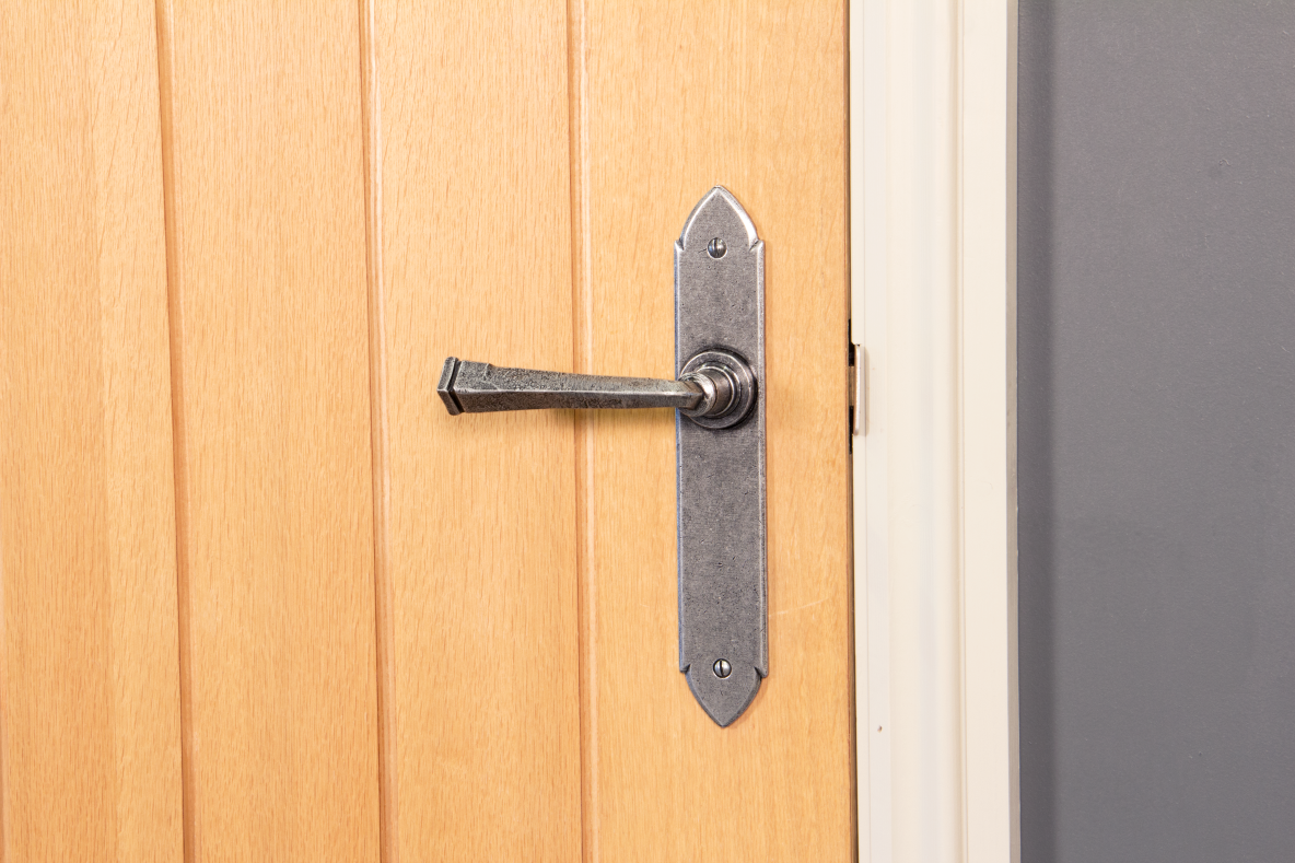 Pewter lever latch door handle fitted to a wooden door