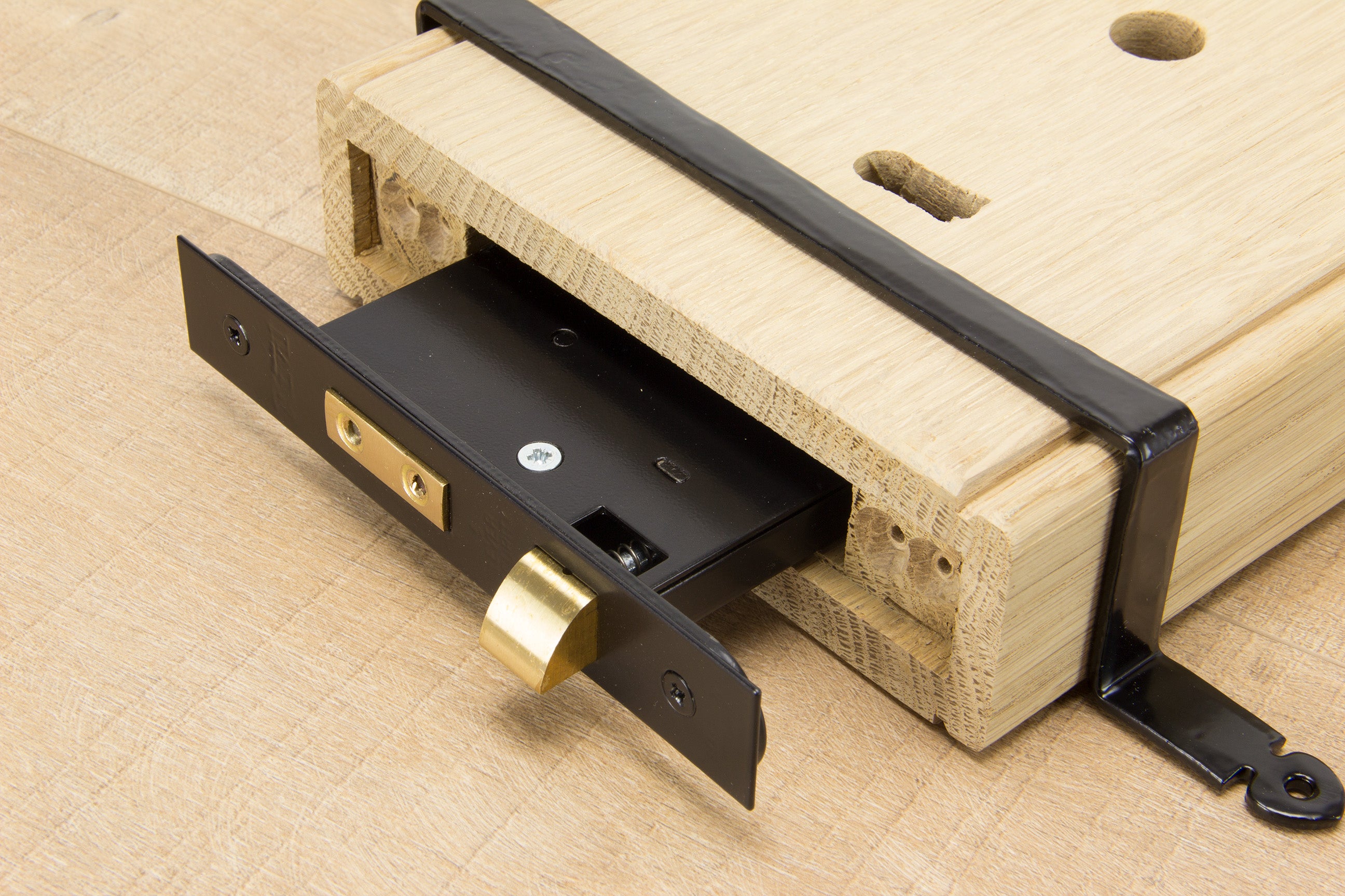 A Black 5 lever lock being inserted into an oak box lock.