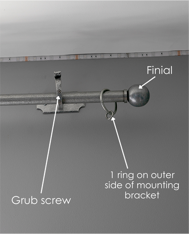 From The Anvil Pewter curtain hardware with arrows pointing to the mounting bracket grub screw, finial, and curtain ring.