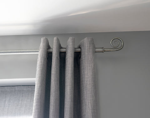 From The Anvil Pewter curtain pole and Monkeytail curtain pole fitted with a grey eyelet curtain.