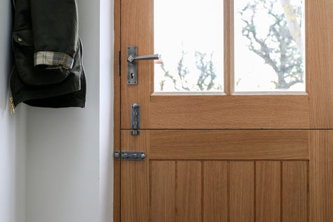 From The Anvil's Pewter Straight knob bolts horizontally and vertically fitted to a wooden stable door with a matching Pewter lever door handle.