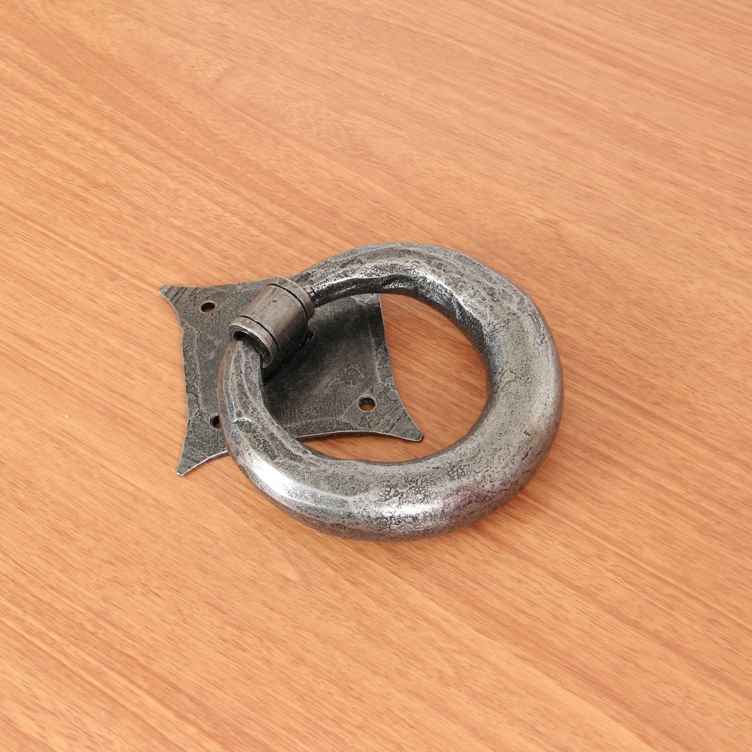From The Anvil's Pewter Ring door knocker positioned on a wooden door.