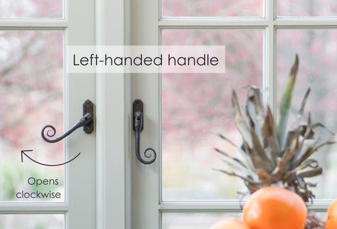 From The Anvil's Beeswax left-handed Monkeytail espag. window handle with an arrow pointing left and the text "Left-handed handle" and "opens clockwise".